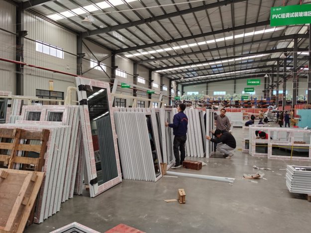 The worker is testing the finished aluminum doors The worker is testing the finished aluminum doors